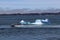 The boat rushes at high speed past an iceberg in the blue bay of Nuuk