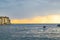 Boat sailing in the Adriatic Sea during sunset of a cloudy day with the typical croatian houses of Rovinj, Croatia, on the left