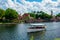 Boat sailing on blue lake and panoramic view of Germany and Italy Pavilions at Epcot in Walt Disney World .