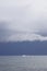 Boat sailing in the upcomming storm. Sailboat in bad weather sail at opened sea. Sailing yacht under heavy cloud sky.