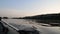 Boat sails along the river, oar of boat touching water and causing splash and ripples in the water.