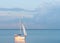 Boat sails and casts orange glowing reflection at blue and pink sky