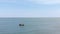 The boat sails on the sea. People sunbathe on the beach. Aerial view of beach and sea. Wave on the sea, ocean. Beach