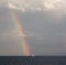 A boat at the sea and a rainbow above the sea in Sydney