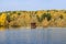 The Boat Shed on quiet colorful lake that reflects autumn leaves, blue sky