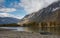 Boat On The Shore. Autumn Mountain Landscape With A River Valley, Beautiful Cloudy Sky And Aluminum Boat On A Stony Shore.