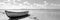 A boat on the shore of a body of water with clouds in the sky, AI