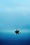 A boat silhouette in a dark blue calm water sea ocean