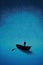 A boat silhouette in a dark blue calm water sea ocean