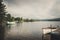 A boat sits on Blue Mountain Lake in a moody summer scene in the Adirondack Mountains.