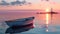 A boat sits in the water at sunset