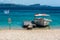 Boat at the small pier on the Beach with Greek flag and warnings