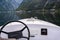 The boat steering wheel on the foreground of Hallstatt village view with Hallstattersee Lake in High Alps Mountains, a  famous