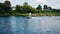 The boat sweeps along the river from right to left. The camera is watching the boat. Nice shots. Water recreation