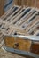 The boat tail of a wooden rowing boat and in the background a series of suspended empty deckchairs lined up in order on the beach