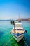 A boat tied on a dock on the crystal clear blue sea