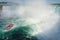 Boat with tourists sailing under the rainbow towards Niagara falls