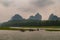 Boat traffic at stretch with banks of Li River in Guilin, China