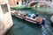 boat for the transport of wine demijohns in canal in venice italy