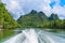 Boat travel on river with exciting view rock overgrown green trees