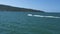 A boat traveling in fast speed in the blue sea to a tropical island on sunny day