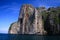 Boat trip along the coast line of tropical island Ko Phi Phi along impressive rock formations under blue sky