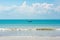 Boat on turquoise water, Bali. Wooden small boat with turquoise sunshade. White clouds, blue sky over ocean, perfect day, holidays