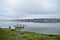 Boat yacht sailboat with motor on river, lake fog over water clouds, green