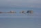 Boater and fisherman passes in front of 3 Arched Rocks