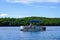 Boaters on pontoon boat enjoy summer day on Lake Placid in New York State`s Adirondack Mountains