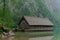 A boathouse on a blue mountain lake with high mountains