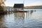 boathouse with jetty and sailing boat in the lake on a sunny autumn day, copy space