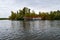 A boathouse with a red roof on the shore of the lake.