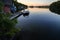 A boathouse with a wakeboard boat parked at it on Lake Joseph at dawn.