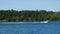 Boating in Minnesota. Gorgeous lake scene with a forest lake, motor boats, docks, cabins, trees and a boat pulling tubers.