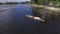 Boatman paddle tiny wooden fishing boat on mountain lake. Drone aerial