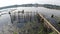 Boatman paddles bamboo raft across polluted lake fish pens