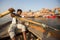 Boatmen on a boat glides through water on Ganges river along shore of Varanasi.