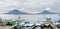 Boats alongside lake Atitlan with volcanoes