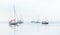 boats are anchored on the water in the ocean, with blue skies in the background