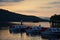 boats behid hill at lake windermere during sunset in the lake district