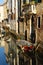 Boats covered from rain parked in the water next to the house in canal of Venice.