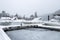 Boats covered in snow in frozen bay at marina