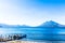 Boats docked at pier with Atitlan & Toliman volcanoes, Lake Atitlan, Guatemala