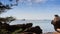 Boats Drift along Skyline Rocks on Beach at Foreground