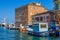 Boats and fishing industrial ships moored in water canal and old buildings on embankment in Chioggia