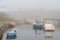 Boats in heavy sea fret at the harbour, at high tide in Seaton Sluice, Northumberland, UK