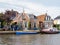 Boats and houses on quay of Ee canal in village of Woudsend in Friesland, Netherlands