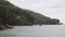 boats lined up at the mouth of the river. view of the river estuary near the beach. mountains background. murky water.