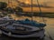 Boats moored on the River Glaven illuminated by the evening glow of the sunset at Blakeney, Norfolk, UK